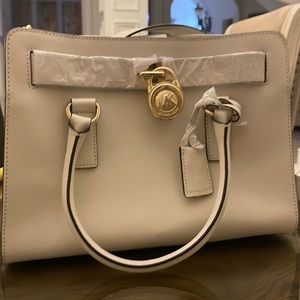 Michael Kors Crème color bag. 13” wide/9” tall/5” wide/Strap 12”.